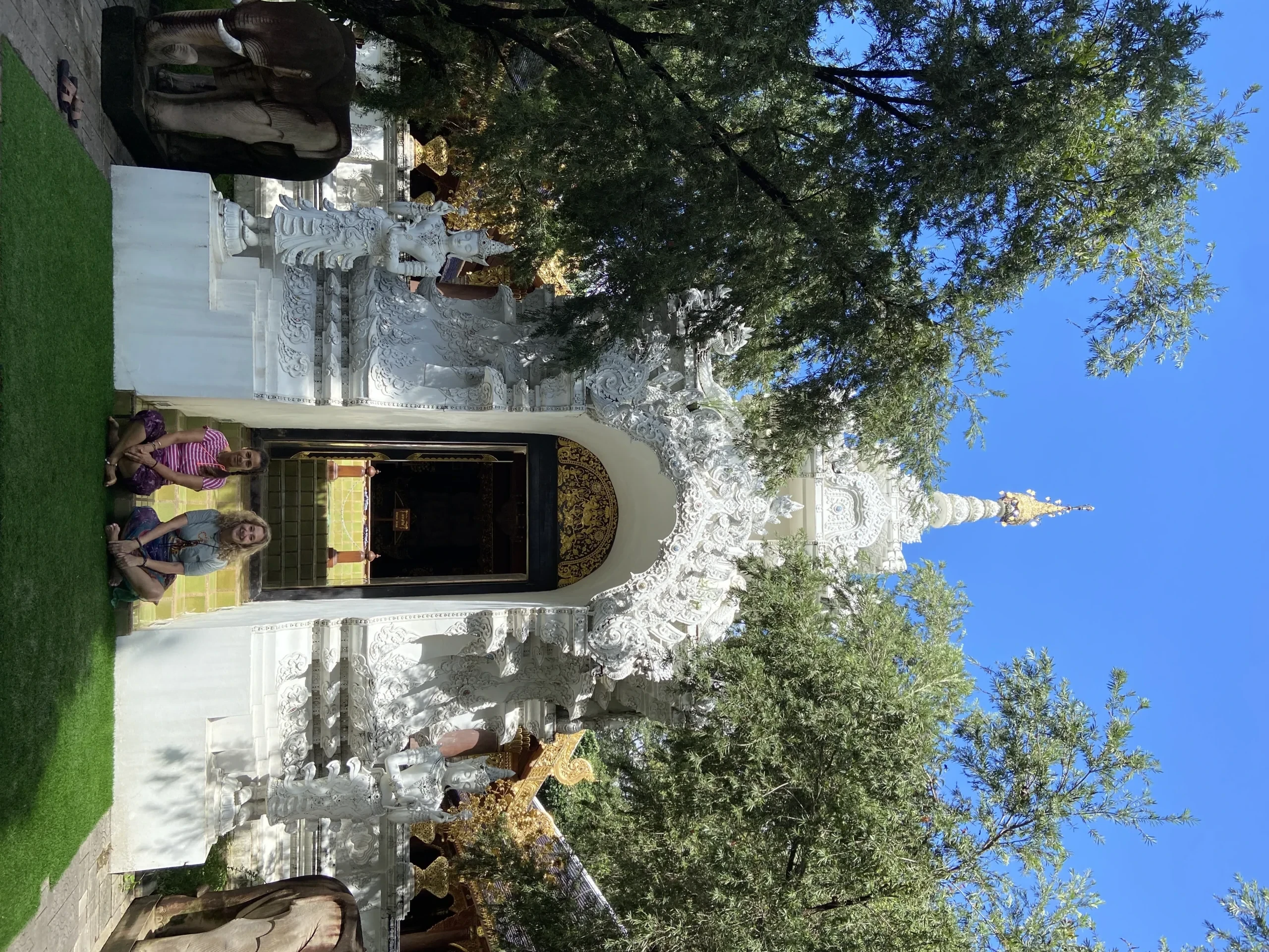 Voluntarias frente a templo budista blanco en Chiang Mai