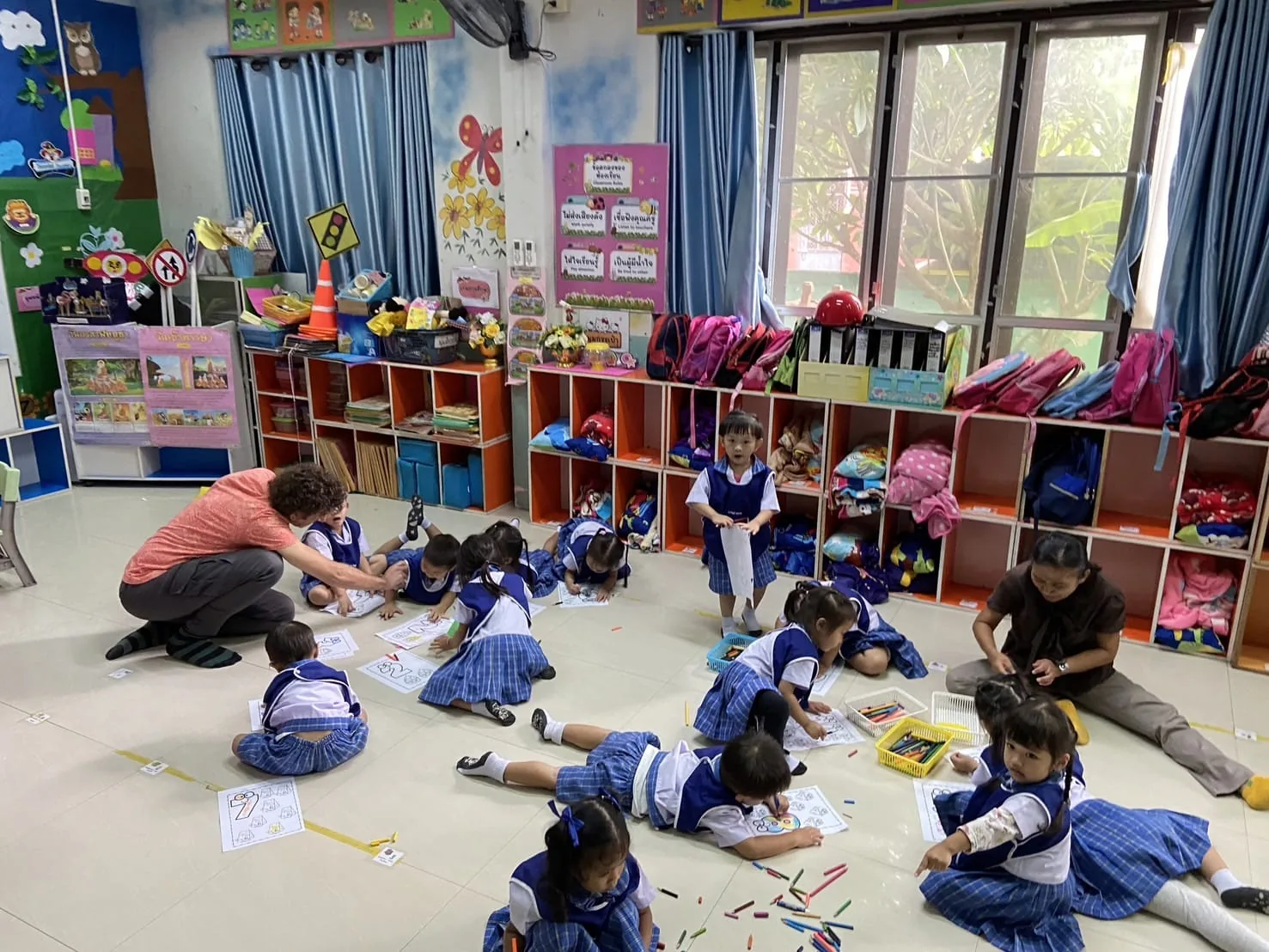 Voluntario en enseñanza a niños en aula de Chiang Mai