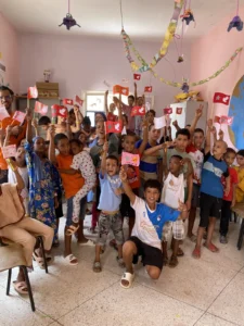 Children and volunteers with flags during the Hands That Unite program in Morocco
