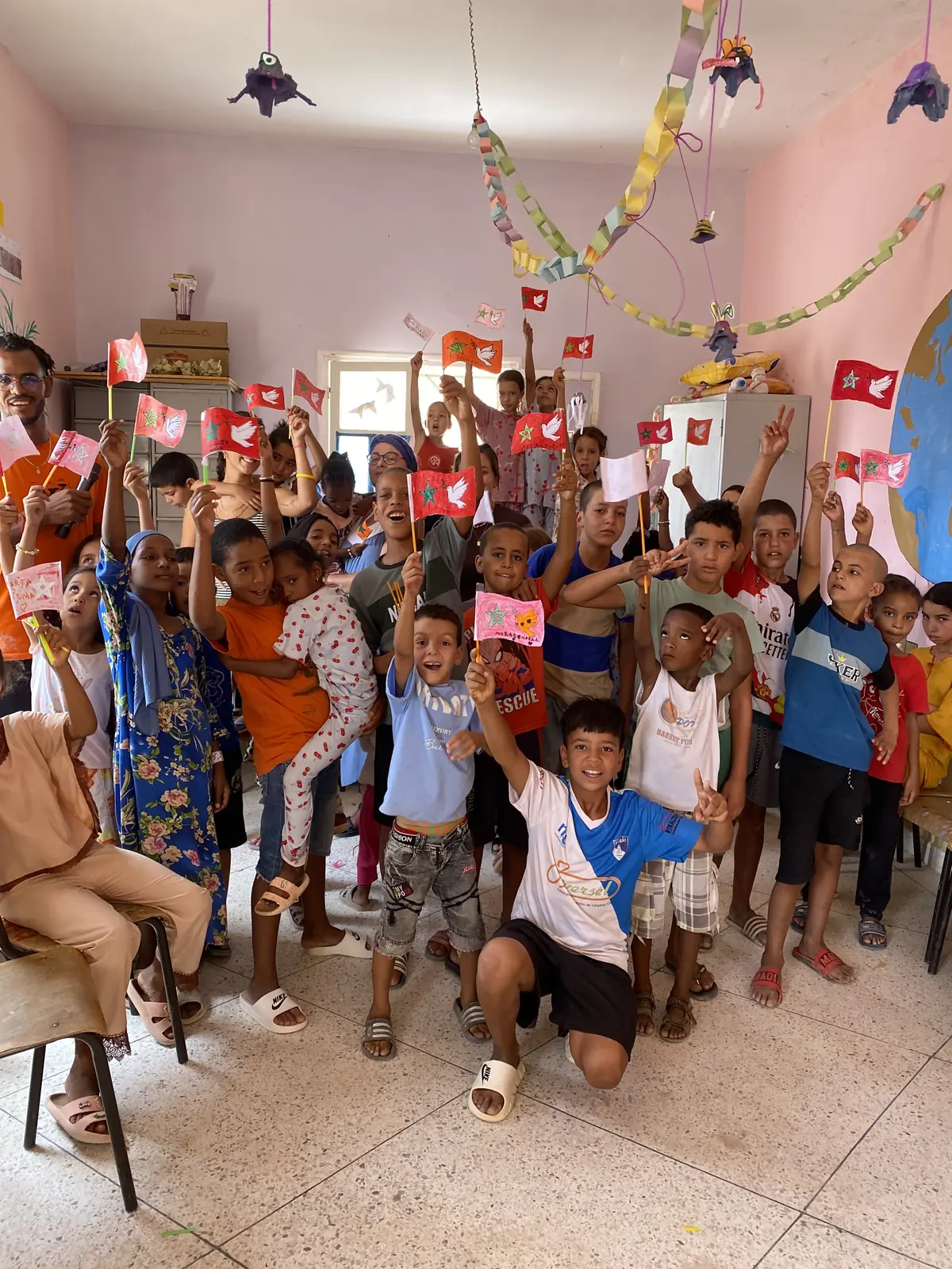 Children and volunteers with flags during the Hands That Unite program in Morocco