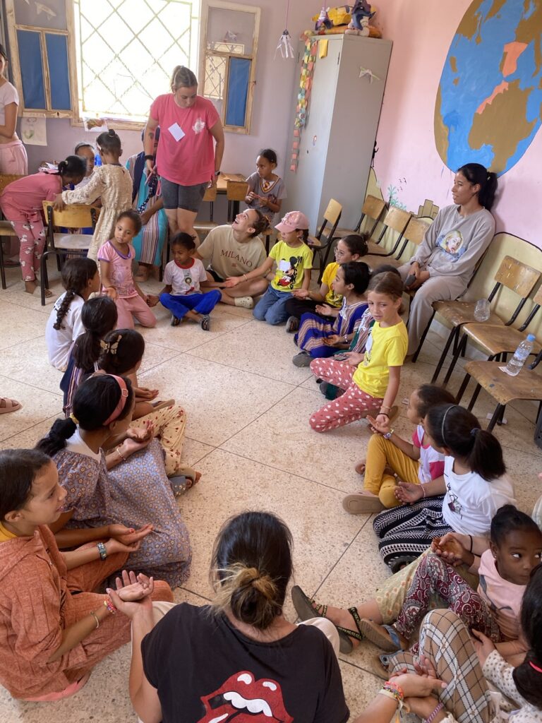 Voluntarias y niños participando en una dinámica educativa en Marruecos